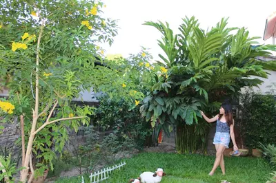 a woman standing in a garden with a dog at Bann In Suan in Ban Lat Tanot