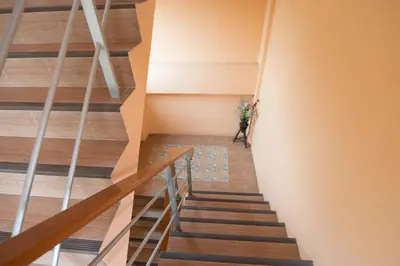 a staircase in a house with a vase of flowers at Bann In Suan in Ban Lat Tanot