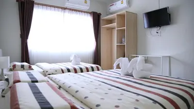 a hotel room with two beds and a television at TD Bangkok in Bangkok