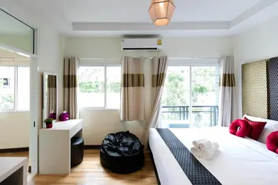 a bedroom with a large bed with pink pillows at Bangkok River Loka Hotel in Bangkok