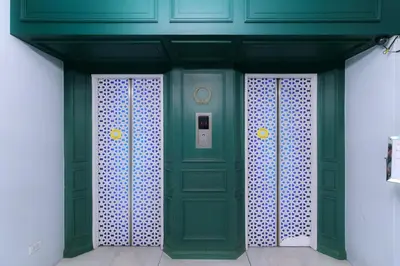 a green door in a building with white walls at Regent Ramkhamhaeng 22 in Bangkok