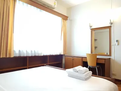 a bedroom with a bed with a mirror and towels at P.T. Court in Bangkok