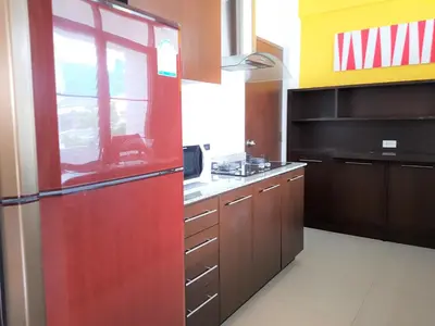 a kitchen with a red refrigerator in a room at P.T. Court in Bangkok
