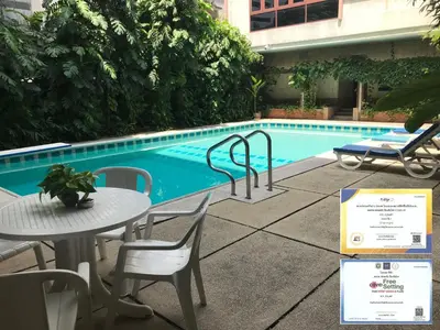a table and chairs next to a swimming pool at P.T. Court in Bangkok