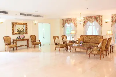 a living room with chairs and a couch and a table at Romance Hotel Bangna in Bangkok