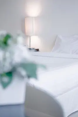 a bedroom with a white bed and a lamp at Romance Hotel Bangna in Bangkok