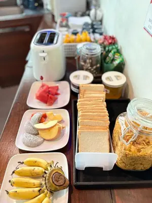 a table topped with different types of food on plates at Luck Yimm Hostel in Bangkok