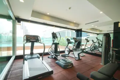 a gym with treadmills and ellipticals in a building at Amora NeoLuxe Suites Hotel in Bangkok
