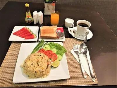 a table with a plate of food on a table at Amora NeoLuxe Suites Hotel in Bangkok