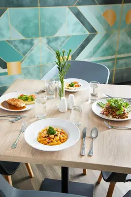 a wooden table with plates of food on it at The Quarter Ladprao by UHG in Bangkok