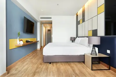 a bedroom with a bed and a blue wall at The Quarter Ladprao by UHG in Bangkok