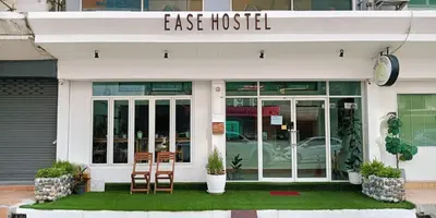 a large white building with two chairs in front of it at Ease Hostel in Bangkok