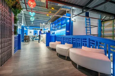 a room with blue dividers and pink chairs at Ama Hostel Bangkok in Bangkok