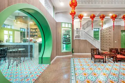 a room with a table and chairs and a staircase at Ama Hostel Bangkok in Bangkok