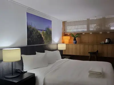 a bedroom with a large white bed with two lamps at Somewhere to Escape - Hometel in Bangkok