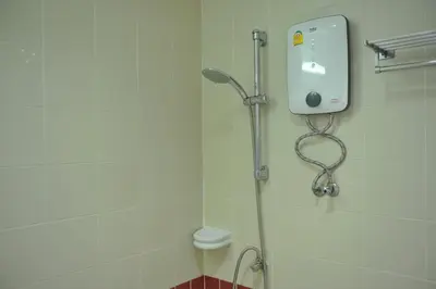 a shower in a bathroom with a shower head at Drop Inn Bangkok in Bangkok