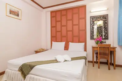 a bedroom with a large bed and a desk at New Siam III Guest House in Bangkok