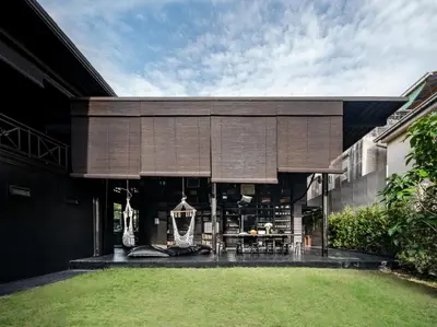 an external view of a house with a grass yard at Kloem Hostel in Bangkok
