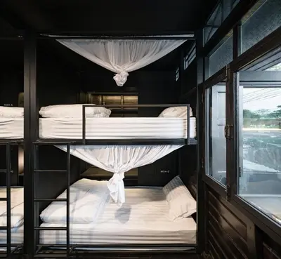 a group of bunk beds in a room with a window at Kloem Hostel in Bangkok