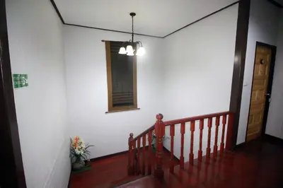 a room with a staircase with a mirror and a window at OB ARUN House in Bangkok