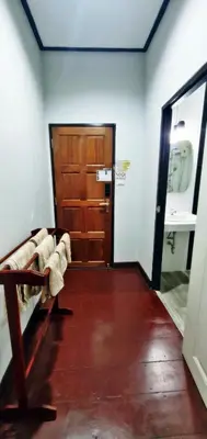 a hallway with a wooden door and a sink at OB ARUN House in Bangkok