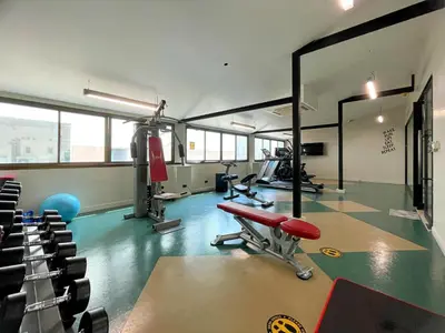 a gym with a red bench and chairs in it at Arawana Regency Park Sukhumvit in Bangkok