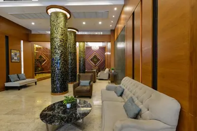 a lobby with a couch and a table and chairs at Arawana Regency Park Sukhumvit in Bangkok
