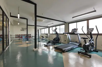 a gym with several treadmills and elliptical machines at Arawana Regency Park Sukhumvit in Bangkok