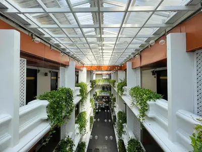 an empty corridor of a building with plants at Arawana Regency Park Sukhumvit in Bangkok