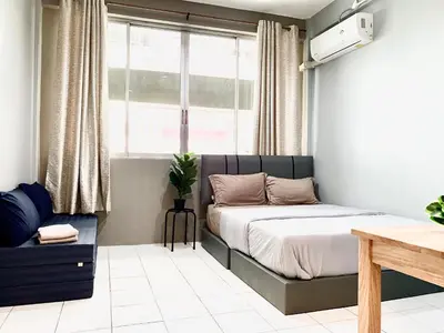 a bedroom with a bed and a window at My Home N1 - BTS Ratchathewi in Bangkok
