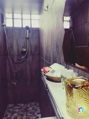 a small bathroom with a shower and a sink at 4J Lodge in Bangkok