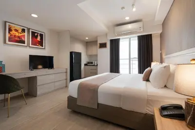 a hotel room with a bed and a television at Aspira Residence Ruamrudee in Bangkok