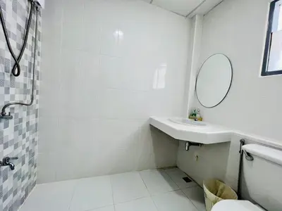 a white bathroom with a sink and a mirror at Bed by Tha-Pra SHA Plus in Bangkok