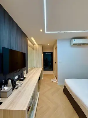 a bedroom with a large television and a bed at Bed by Tha-Pra SHA Plus in Bangkok