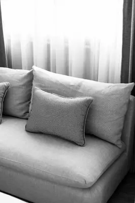 a couch with pillows sitting in front of a window at Apartelle Jatujak Hotel in Bangkok