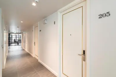 a hallway with white walls and a door at Apartelle Jatujak Hotel in Bangkok