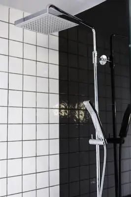 a shower with a shower head in a bathroom at Apartelle Jatujak Hotel in Bangkok