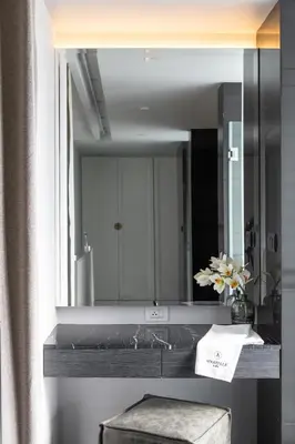 a bathroom with a sink and a mirror at Apartelle Jatujak Hotel in Bangkok