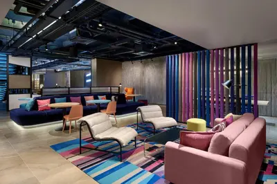 a lobby with couches and chairs and tables at Aloft Bangkok - Sukhumvit 11 in Bangkok