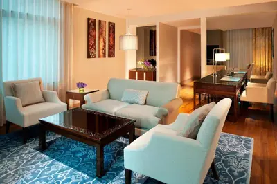 a living room with couches chairs and a table at The St. Regis Bangkok in Bangkok