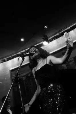 a woman in a dress singing into a microphone at Sheraton Grande Sukhumvit, a Luxury Collection Hotel, Bangkok in Bangkok