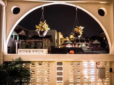 a balcony with two potted plants on a building at Tian Tian Hostel in Bangkok