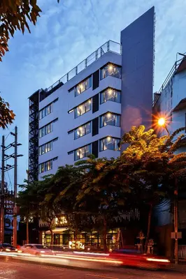 a tall building with lights in front of it at Rest24 Residence in Bangkok