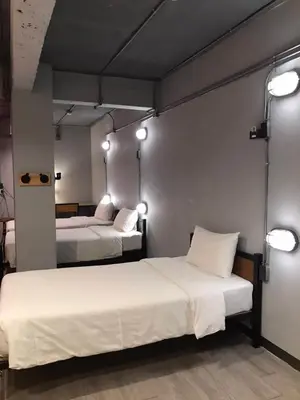 two beds in a room with lights on the wall at Rest24 Residence in Bangkok