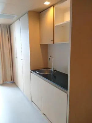 a kitchen with a sink and white cabinets at The Tivoli Hotel in Bangkok