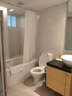 a bathroom with a white toilet and a sink at The Tivoli Hotel in Bangkok