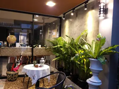 a table and chairs in a room with plants at Alley living rama8 in Bangkok