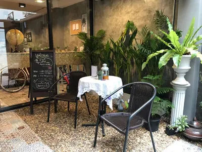 a table and chairs in a room with plants at Alley living rama8 in Bangkok