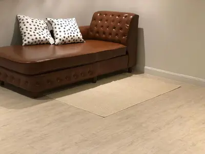 a brown leather couch with pillows on a floor at Alley living rama8 in Bangkok