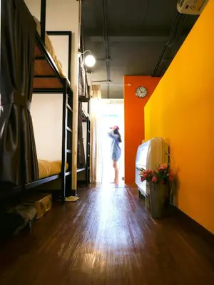 a person standing in a room with bunk beds at Bangkok Sanookdee Hostel in Bangkok